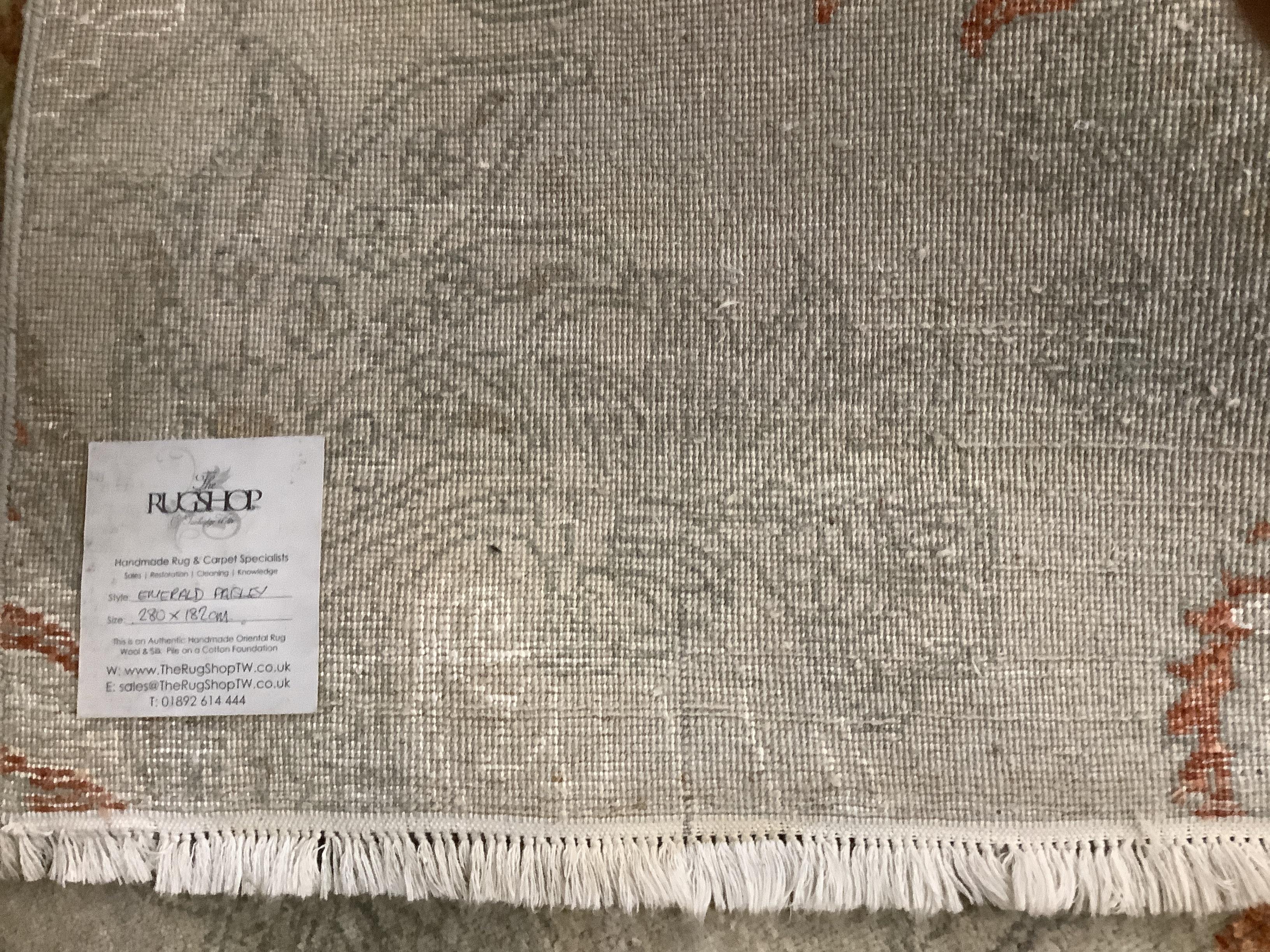 A handmade Oriental Emerald Paisley pattern carpet, retailed by The Rug Shop, Tunbridge Wells, 284 x 182cm